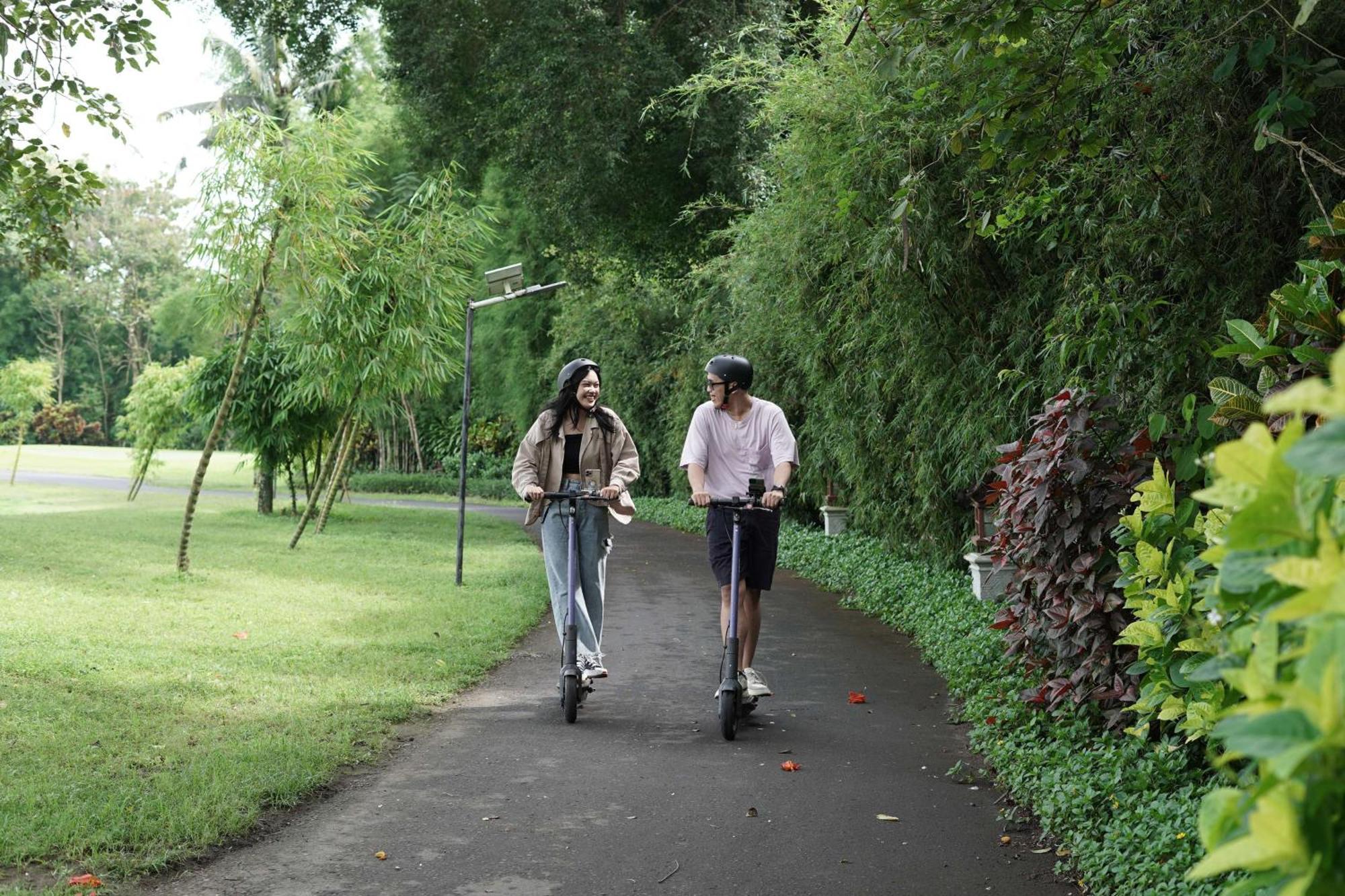 凯悦日惹酒店 斯勒曼 外观 照片 Two people riding scooters in a park